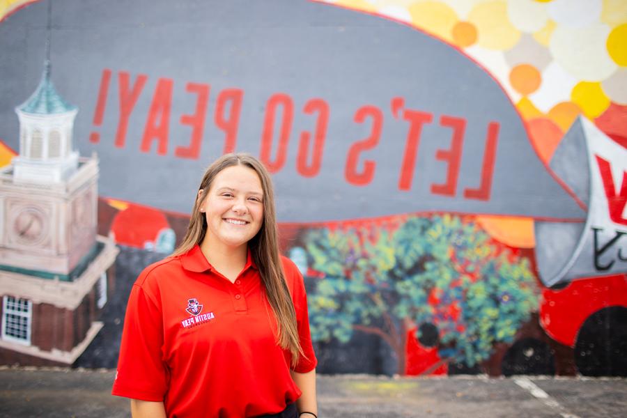 Alex Edwards in front of the Let's Go Peay! mural.